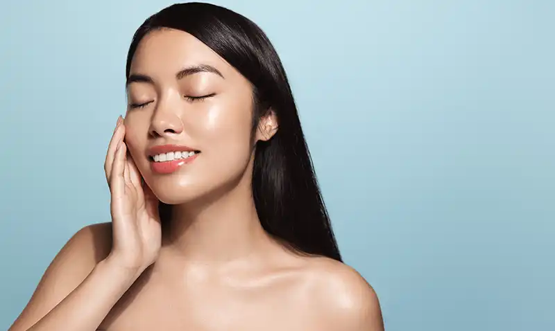 Modella coreana con pelle luminosa ed idratata, esempio di effetto glass skin ottenuto con prodotti fermentati e bava di lumaca.
